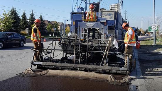 Work crew micro sealing a road