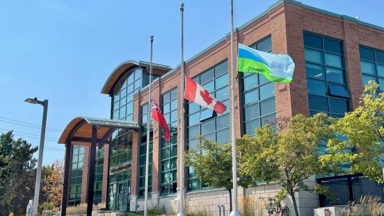 Town Hall flags flying at half mast on a sunny summer day