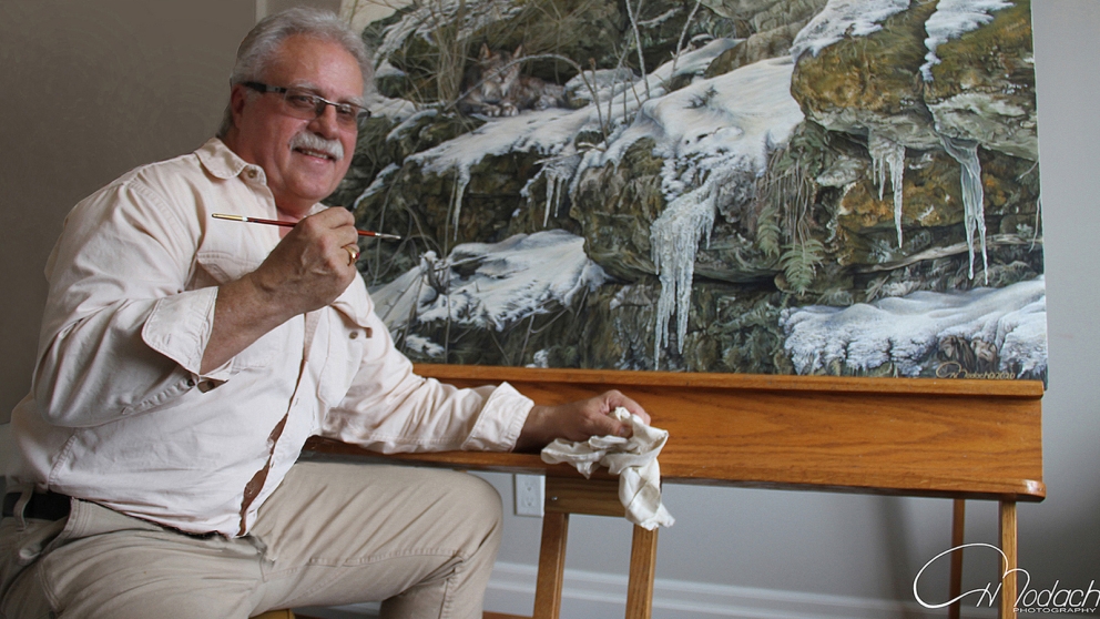 Portrait of Harvey Bodach in front of easel