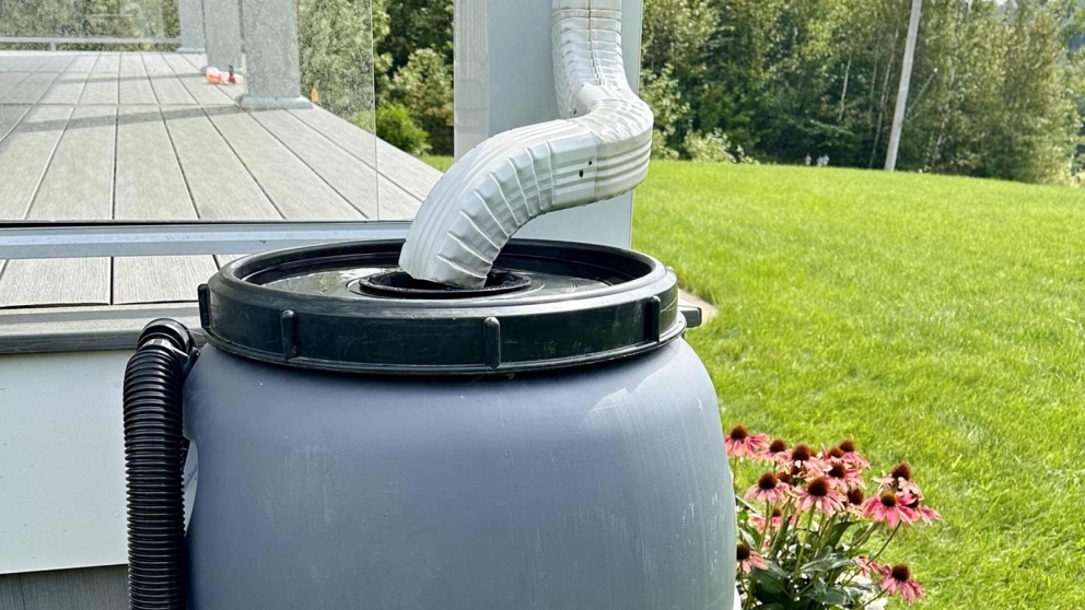 rain barrel beside deck with downspout directed into it