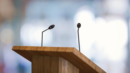 Close up of speaker's podium with microphones