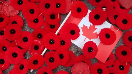 Poppies scattered over a small Canadian flag