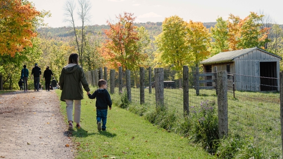 Adult and child walking towards barn