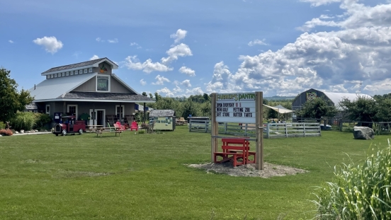 Barn with green grass and sign in foreground