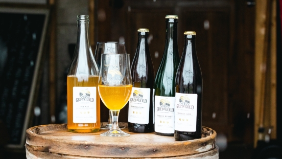 Bottles of cider sitting on oak barrel