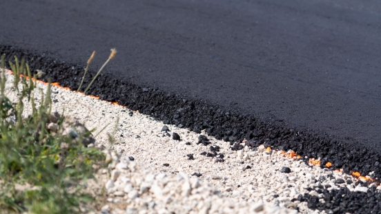 Fresh asphalt next to white gravel