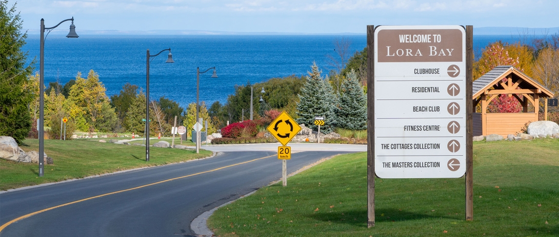 Lora Bay sign in foreground with Georgian Bay in background
