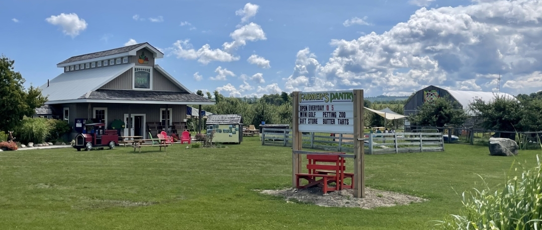 Barn with green grass and sign in foreground