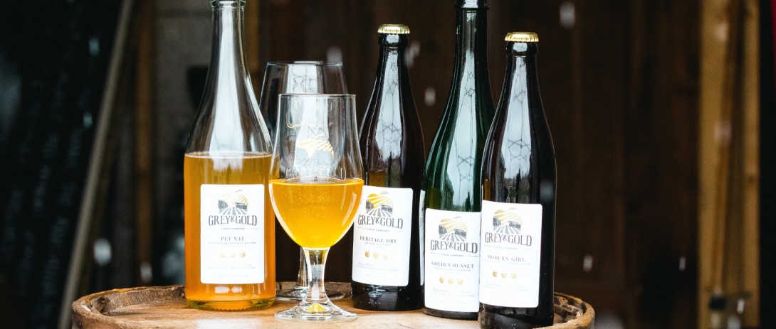 Bottles of cider sitting on oak barrel