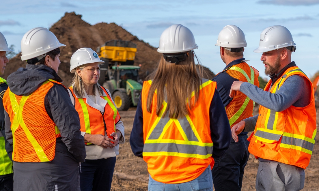 Group of people in construction vests talking in circle