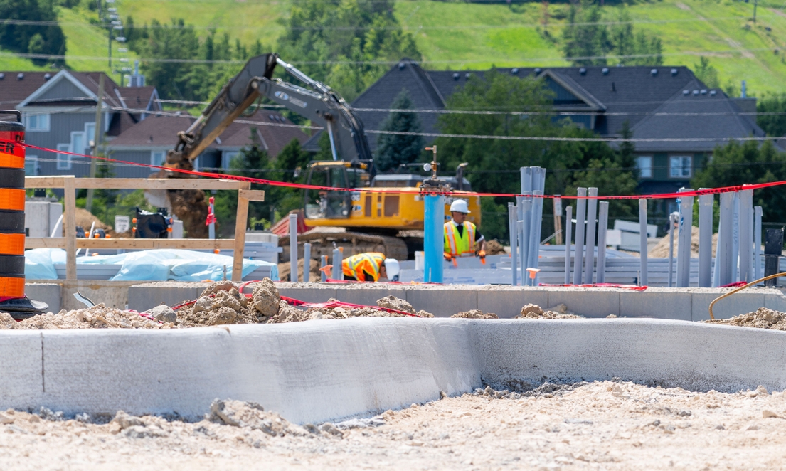 Newly poured curb with foundation prep happening in the background