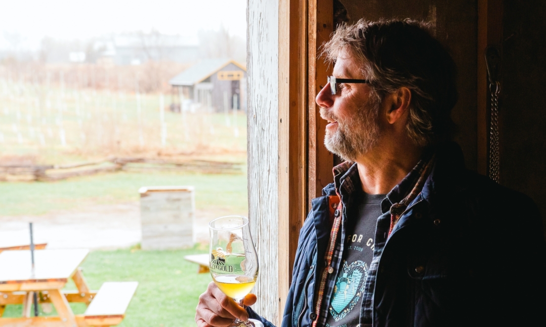 David Baker looks out over his property from inside the barn