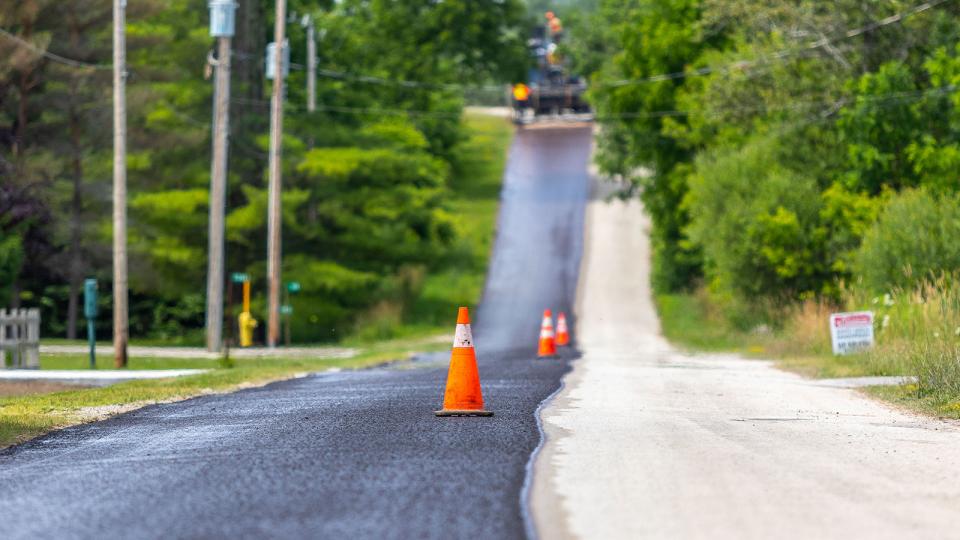 Freshly resurfaced road with traffic pylons