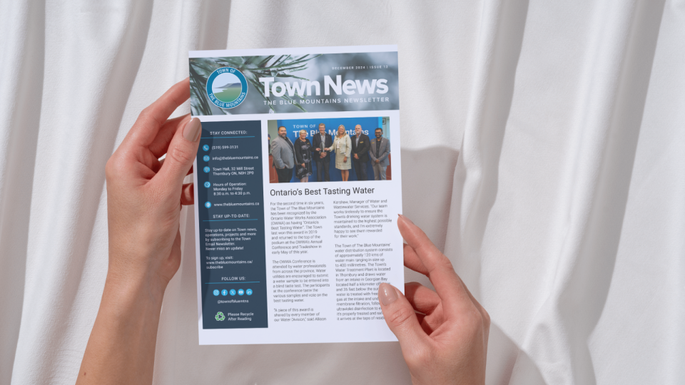 Hands holding a copy of the 2024 Mailed Newsletter